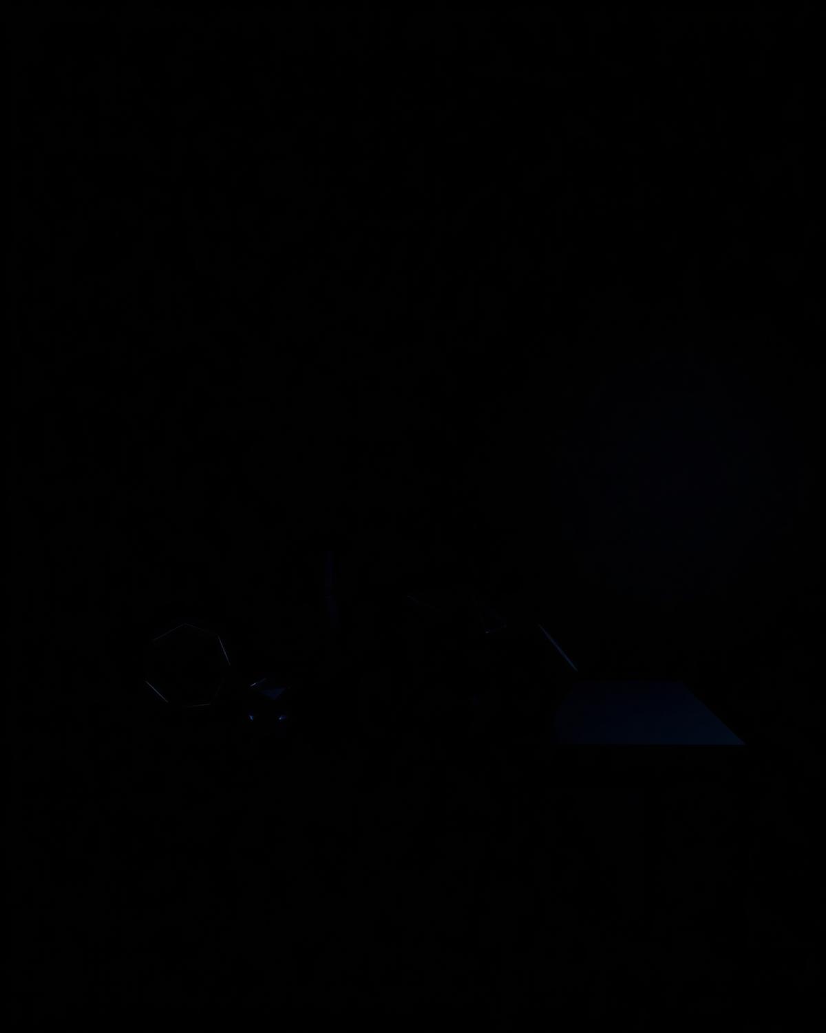 Dark tabletop with abstract geometric objects under low blue light